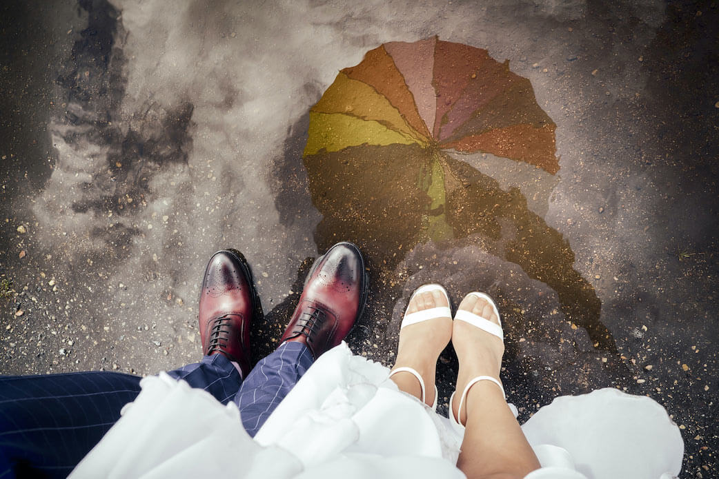 Nahaufnahme der Schuhe des Brautpaares bei einer Hochzeit im Regen