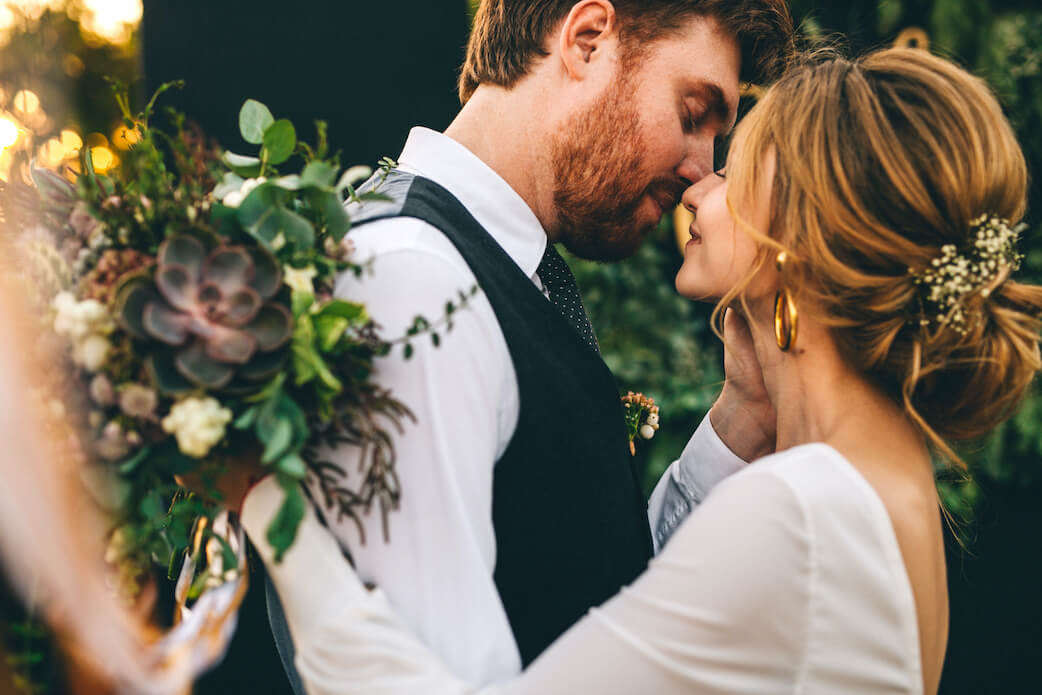 Das glückliche Brautpaar küsst sich nach der Trauung. Die Namenswahl hat beide glücklich gestimmt. Wer hat wohl wessen Namen angenommen?
