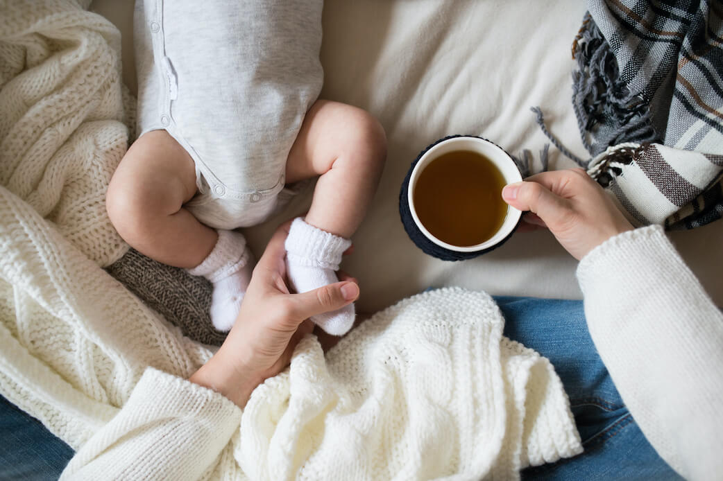 Nahaufnahme von Babyfüßchen mit Söckchen, die zur Geburt geschenkt wurden