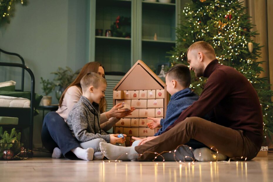 Eine Familie sitzt vor einem selbst befüllten Adventskalender. 
