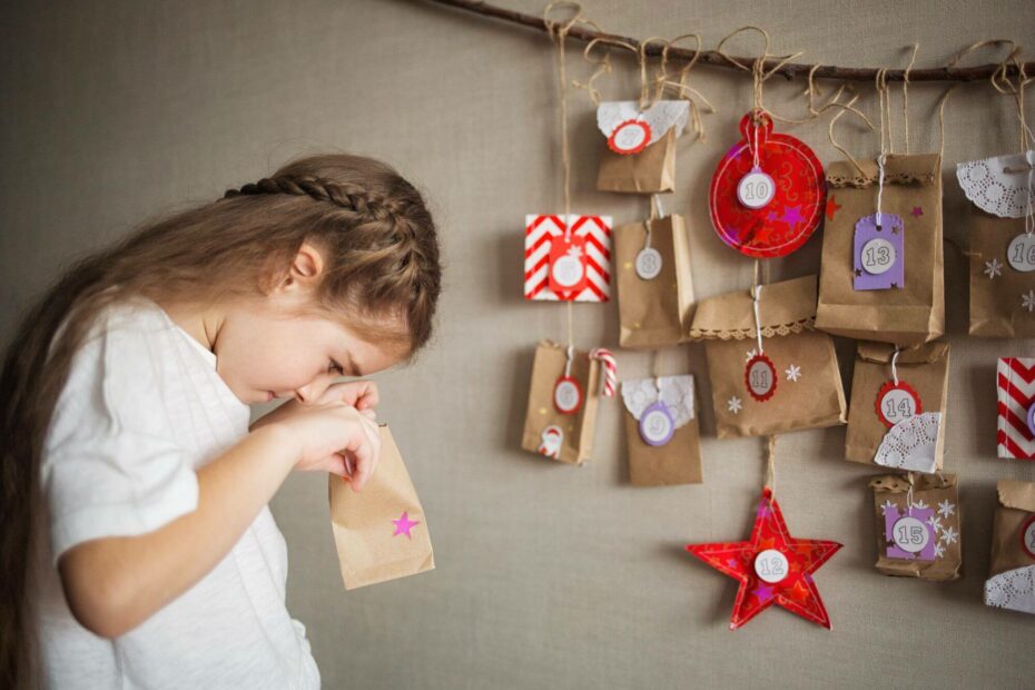 Kind öffnet selbst befüllten Adventskalender.