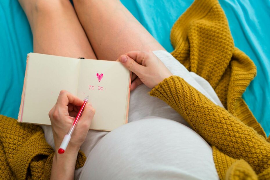 Schwangere Frau schreibt eine To-Do-Liste 