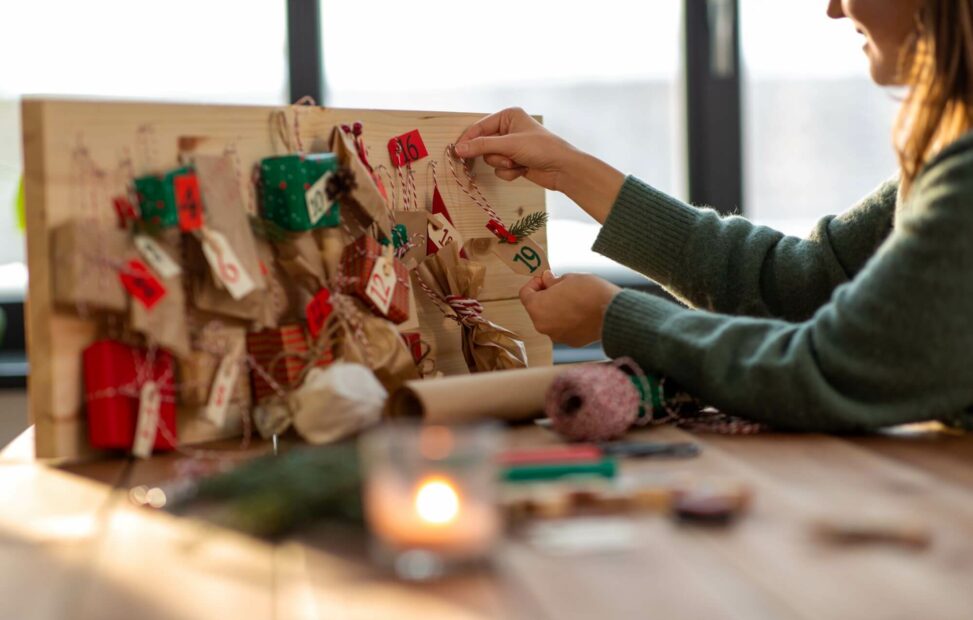 Frau befüllt Adventskalender selber. 